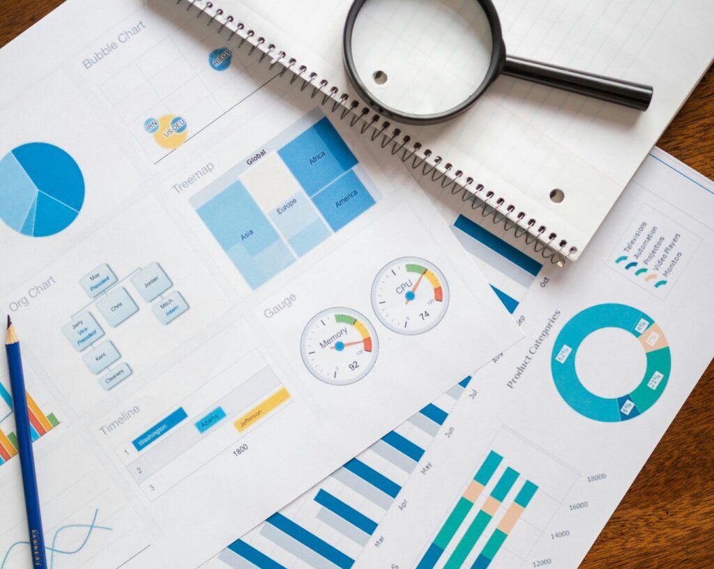 A set of financial charts and graphs with a magnifying glass, perfect for business reports.